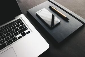 Clavier, téléphone et carnet posés sur un bureau pour un service rédaction Web SEO professionnel.