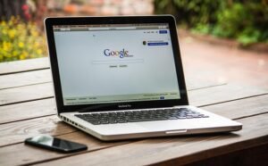Macbook Pro affichant page Google sur écran, travail de freelancer avec laptop, internet, SEO et technologie.