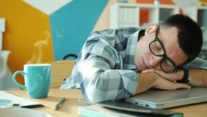 thérapeute seule bureau fatigue, homme avec lunettes endormi au travail devant ordinateur portable au bureau